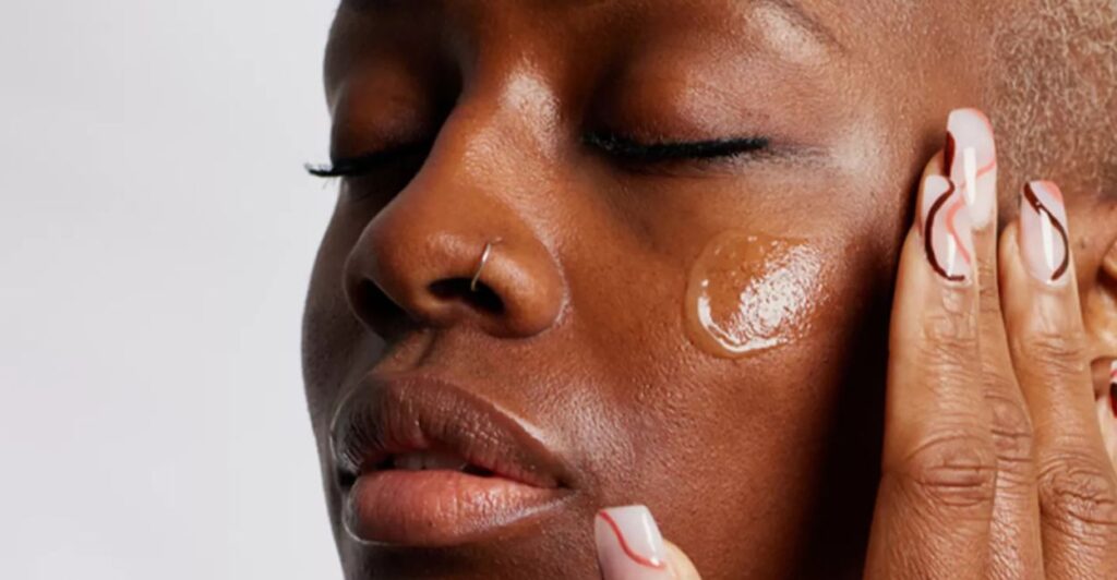 Rosto mulher pele negra com serum.