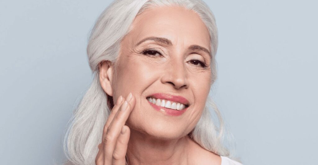 Rosto mulher meia idade apreciando sua pele e sorrindo, mostrando pele perfeita - colágeno