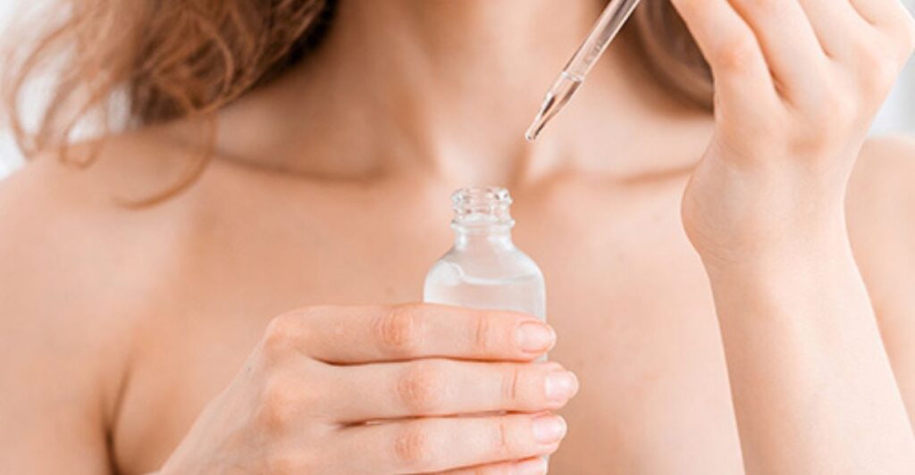 Colo de mulher jovem com frasco de soro na mão